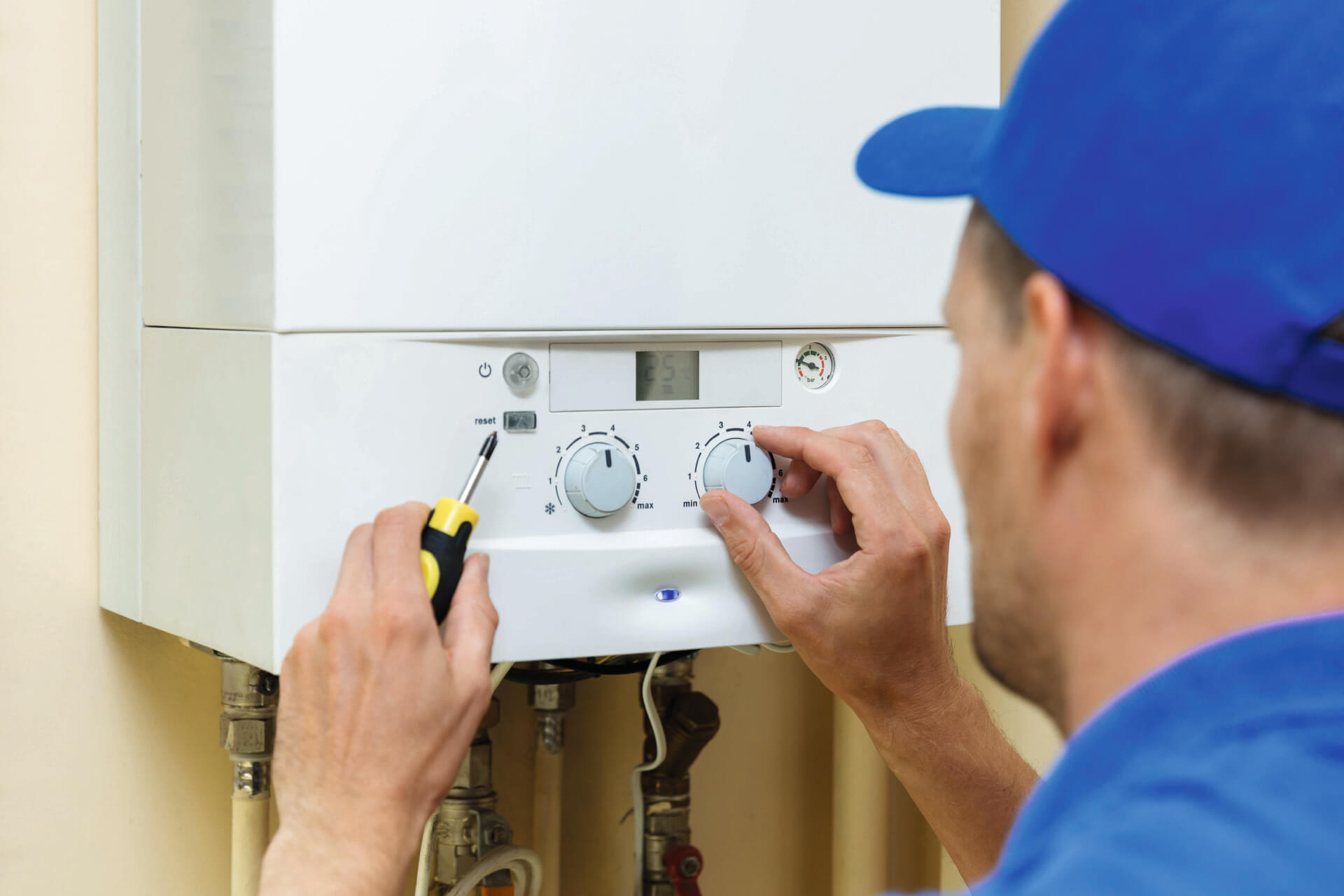 worker set up central gas heating boiler at home